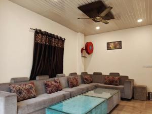 a living room with a couch and a ceiling fan at Hotel Sudarshan in Haridwār