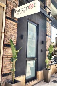 a front door of a restaurant with two potted plants at Bedspot Heraklion in Heraklio