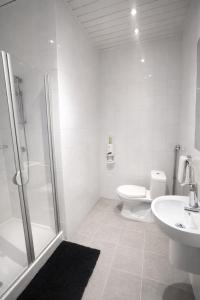 a bathroom with a shower and a toilet and a sink at Nous Cafe & Restaurant in Krumnussbaum