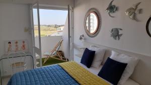 a bedroom with a blue and yellow bed and a mirror at RIEZ Entre Mer et Dunes in Saint-Hilaire-de-Riez