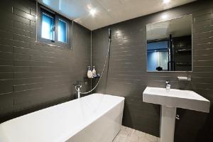 ソウルにあるMWホテルの白い浴槽と洗面台のあるバスルーム +21枚の写真