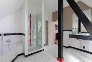 a bathroom with a shower and a tub and a sink at Sheraton Hannover Pelikan Hotel in Hannover