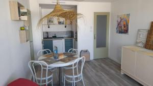 a kitchen with a table and chairs in a room at RIEZ Entre Mer et Dunes in Saint-Hilaire-de-Riez