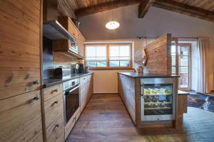 a kitchen with wooden cabinets and a stove top oven at Panorama Chalets by we rent, JOKERCARD INCLUDED in Saalbach-Hinterglemm