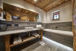 a large bathroom with a tub and a sink at Panorama Chalets by we rent, JOKERCARD INCLUDED in Saalbach-Hinterglemm +13 photos