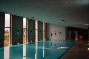 a large swimming pool in a building with windows at Feriecenter Slettestrand in Fjerritslev