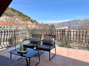 two chairs and a table on a balcony with a view at Apartman Romić in Vrlika