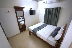 a small bedroom with a bed and a mirror at Blessings select DLF in Chennai +8 photos