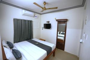 a small bedroom with a bed and a ceiling fan at Blessings select DLF in Chennai