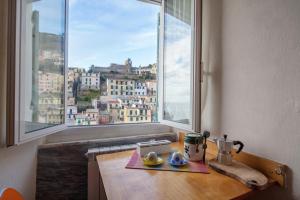 a kitchen with a table with a view of a city at Beautiful view apartment Riomaggiore, Cinque Terre in Riomaggiore