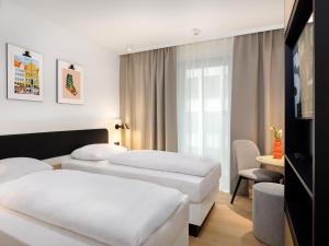 a hotel room with two beds and a window at smartments Bielefeld Hauptbahnhof in Bielefeld +49 photos