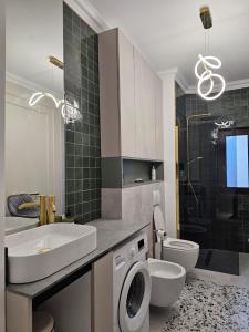 a bathroom with a sink and a washing machine at ISHotel in Craiova +35 photos