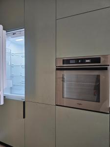 a kitchen with an open refrigerator and an oven at ISHotel in Craiova
