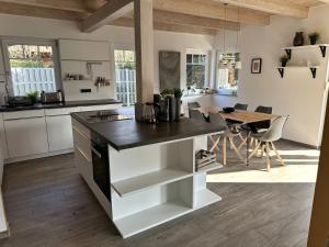 a kitchen with white cabinets and a black counter top at Brückelsee-Chalet in Wackersdorf