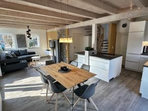 a kitchen and living room with a wooden table and chairs at Brückelsee-Chalet in Wackersdorf +39 photos