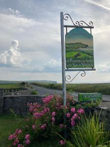 a sign on the side of a road with flowers at Ceol na dTonnta in Doolin