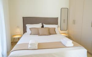 a bedroom with a large white bed with towels on it at Villa Artemis 4 - Etheras Properties in Kythira
