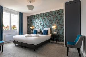 a bedroom with a bed and a blue wall at Mercure Paris Saint Cloud Hippodrome in Saint-Cloud +176 photos