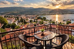 a balcony with a table and chairs and a view of a city at Villa Mesokastro in Ohrid
