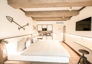 a bedroom with a large white bed and a kitchen at Hotel the Farmhouse No 50 - kostenfreies Parken! - Cafe & Eventrooms in Osnabrück +138 photos
