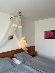 a bedroom with a bed with a mosquito net at Hotel Landhaus Adensen in Nordstemmen
