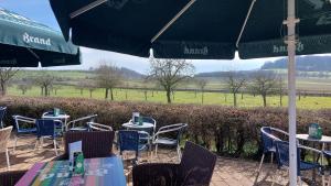 a group of tables with chairs and an umbrella at Bed & Breakfast Hotel Het Gerendal in Valkenburg