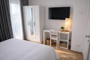 a bedroom with a bed and a table and a tv at Bormio7 con parcheggio, pista ciclabile, vicino piste sci e terme in Valdisotto