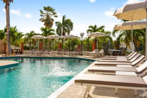 a swimming pool with lounge chairs and umbrellas at Parasasa Hotel Curacao in Willemstad