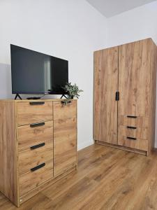 a wooden dresser with a television on top of it at At Ladyluck in Suceava