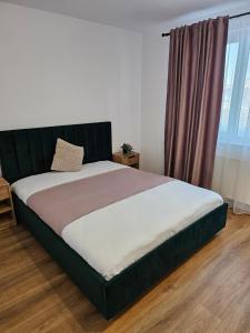 a large bed in a bedroom with a window at At Ladyluck in Suceava