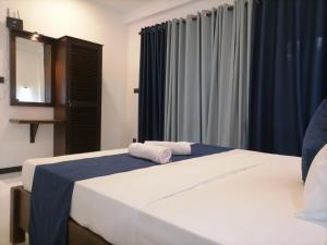 a bedroom with a bed with two towels on it at The Vinza in Hikkaduwa