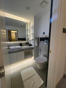 a bathroom with a white toilet and a sink at Divine OAK Stay in Narendranagar