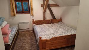 a bedroom with a wooden bed in a room at Chalupa U Kapličky Pastviny in Pastviny