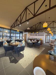 a restaurant with tables and chairs and windows at Divine OAK Stay in Narendranagar