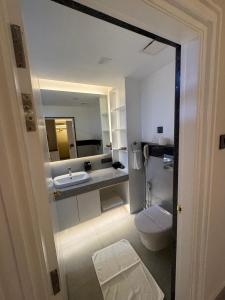 a bathroom with a sink and a toilet and a mirror at Divine OAK Stay in Narendranagar
