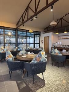 a dining room with tables and chairs and windows at Divine OAK Stay in Narendranagar