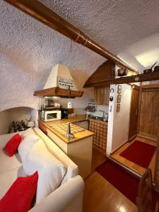 a living room with a couch and a kitchen at Rifugio del vicolo in Lucoli Alto