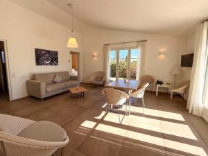 a living room with a couch and a table and chairs at Clos des Oliviers Grimaud - Meublé de Tourisme in Grimaud