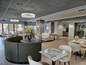 a restaurant with white chairs and tables and tablesktop at Hotel Három Gúnár in Kecskemét +34 photos