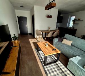 a living room with a blue couch and a table at Apartments Javor in Veľký Slavkov