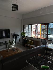 a living room with a couch and some windows at Only fan guesthouse in Chumphon