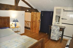a bedroom with a bed and a desk and a chair at Les Glycines Gîtes - Les Petites Pierres gîte - shared solar heated pool - garden spa - small dogs welcome in Vernoux-en-Gâtine +15 photos