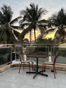 a table and two chairs on a balcony with palm trees at Room 01 in Serekunda