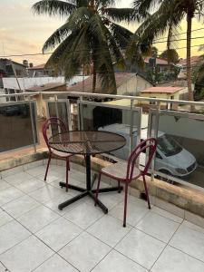 a table and two chairs on a balcony with a car at Room 01 in Serekunda