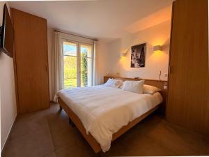 a bedroom with a large bed and a window at Clos des Oliviers Grimaud - Meublé de Tourisme in Grimaud +67 photos