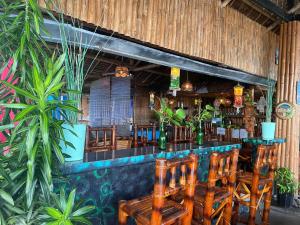 a bar in a restaurant with wooden chairs at Satosa Beach Resort in San Joaquin