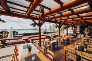 a restaurant with wooden tables and chairs on a deck at Penzion Rak Wellness in Černá v Pošumaví