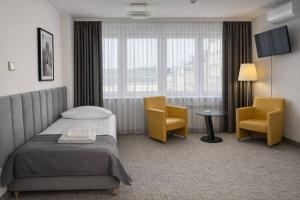 a hotel room with a bed and two chairs at Hotel Logos in Warsaw +53 photos