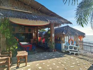 a building with a restaurant next to the ocean at Satosa Beach Resort in San Joaquin