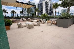 a patio with chairs and tables on a building at Lujoso apartamento ,The Crosby Miami World Center in Miami